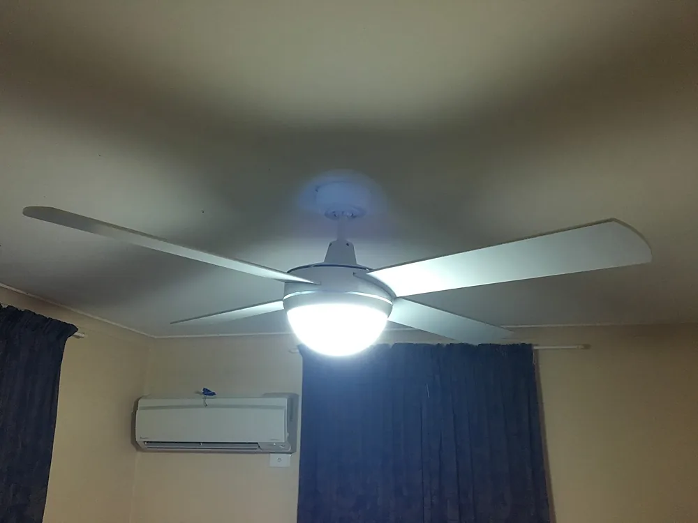 White ceiling fan with a light kit installed in a bedroom