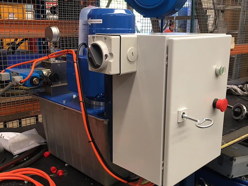 Control panel with an isolator wired to a hydraulic unit in a workshop