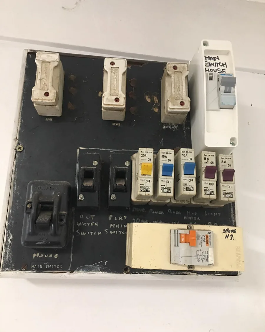 Old switchboard with ceramic rewireable fuses on a black panel