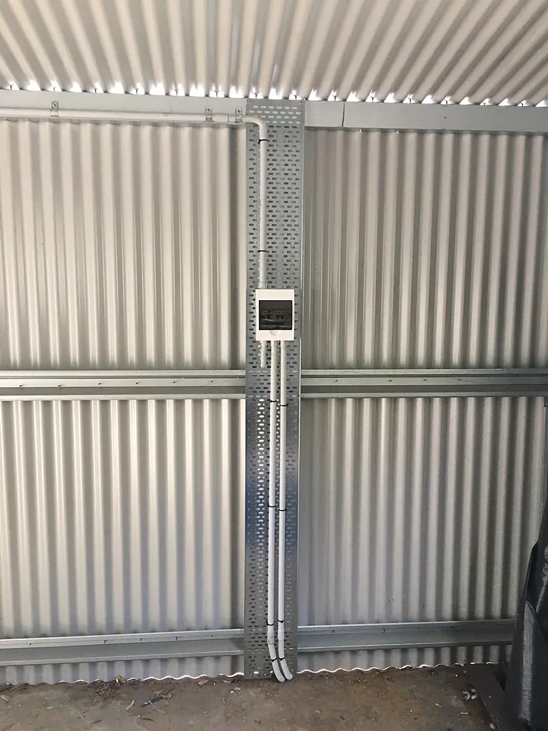 Conduit run on a corrugated shed wall