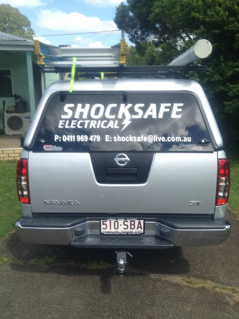 The silver Shocksafe Electrical work ute with signage on the rear window